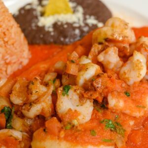 Red Shrimp Enchiladas / shrimps are on top and filled with cheese.