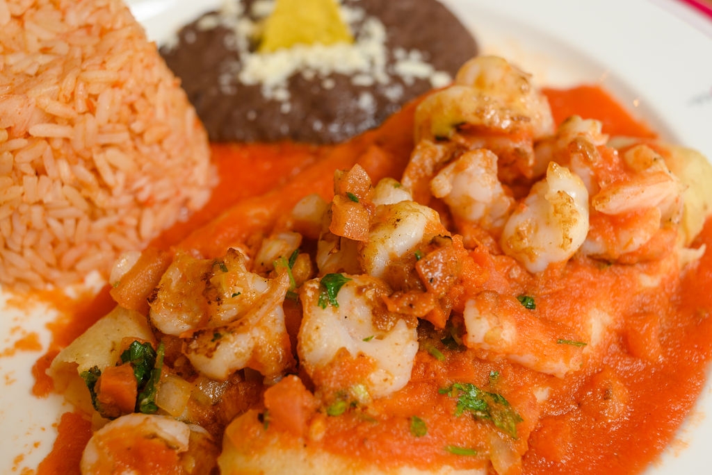 Red Shrimp Enchiladas / shrimps are on top and filled with cheese.