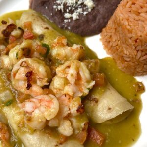 Green Shrimp Enchiladas / shrimps are on top and filled with cheese.